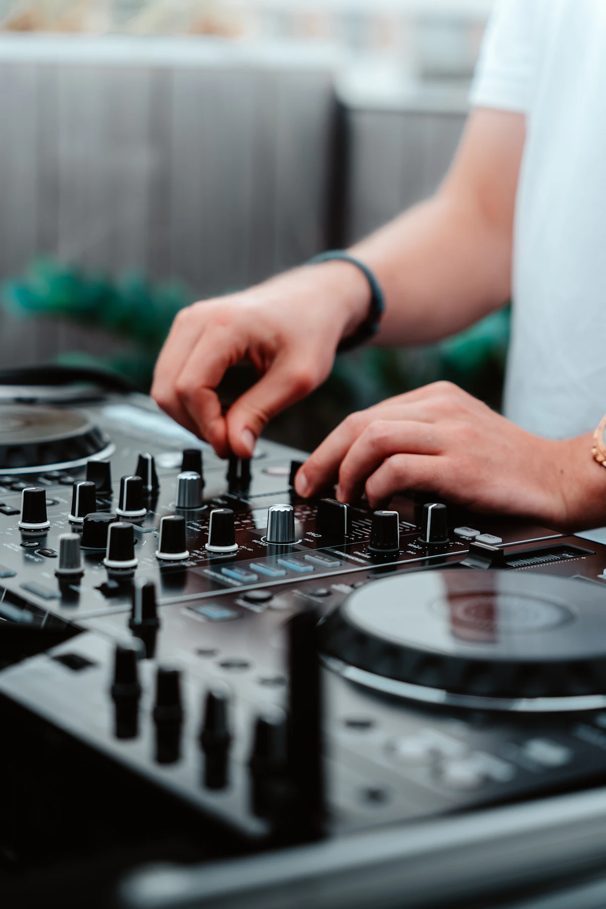 A DJ adjusting the controls of a mixing console
